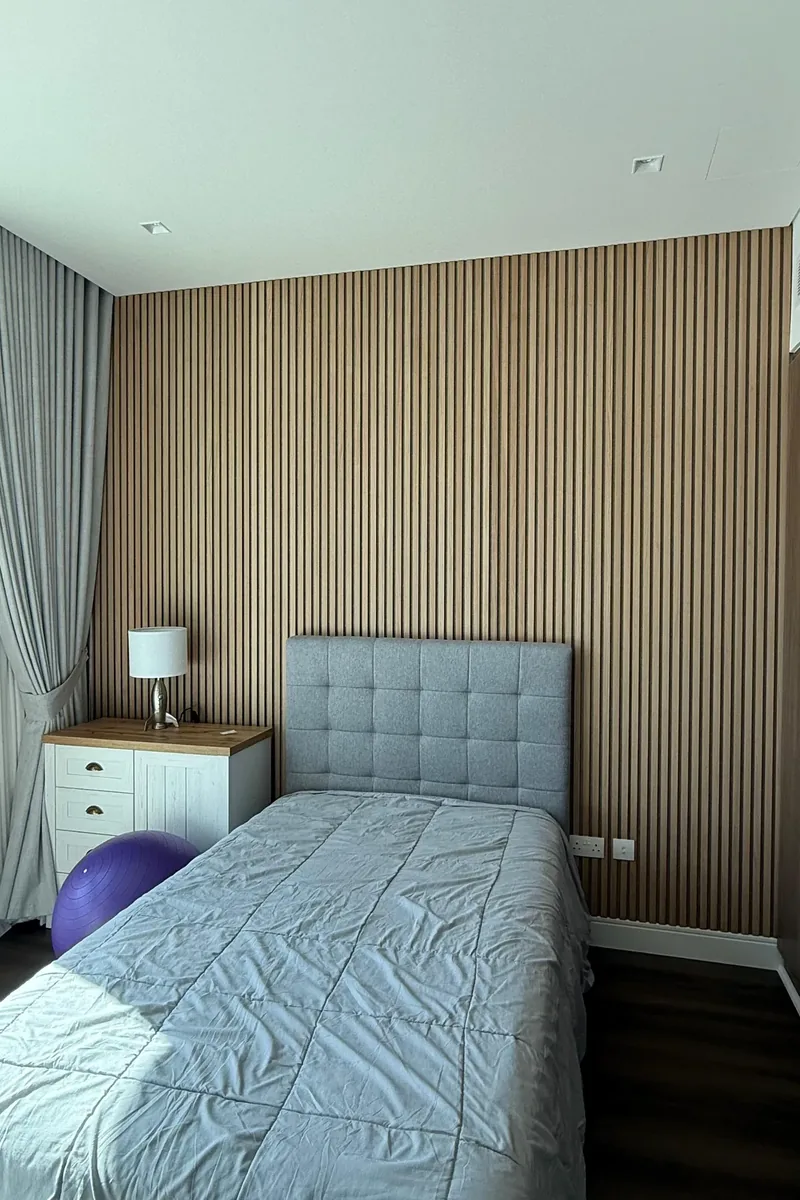 Bedroom wall clad in full-height slatted panels, a finished ApexCore project