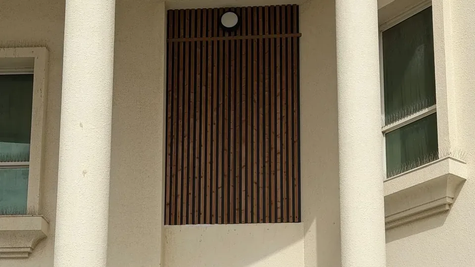 Exterior slatted panels installed in the entrance niche of a villa