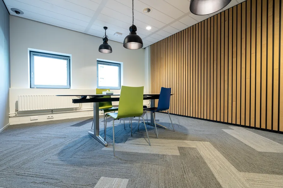 Meeting room with a full-height vertical timber-slat wall